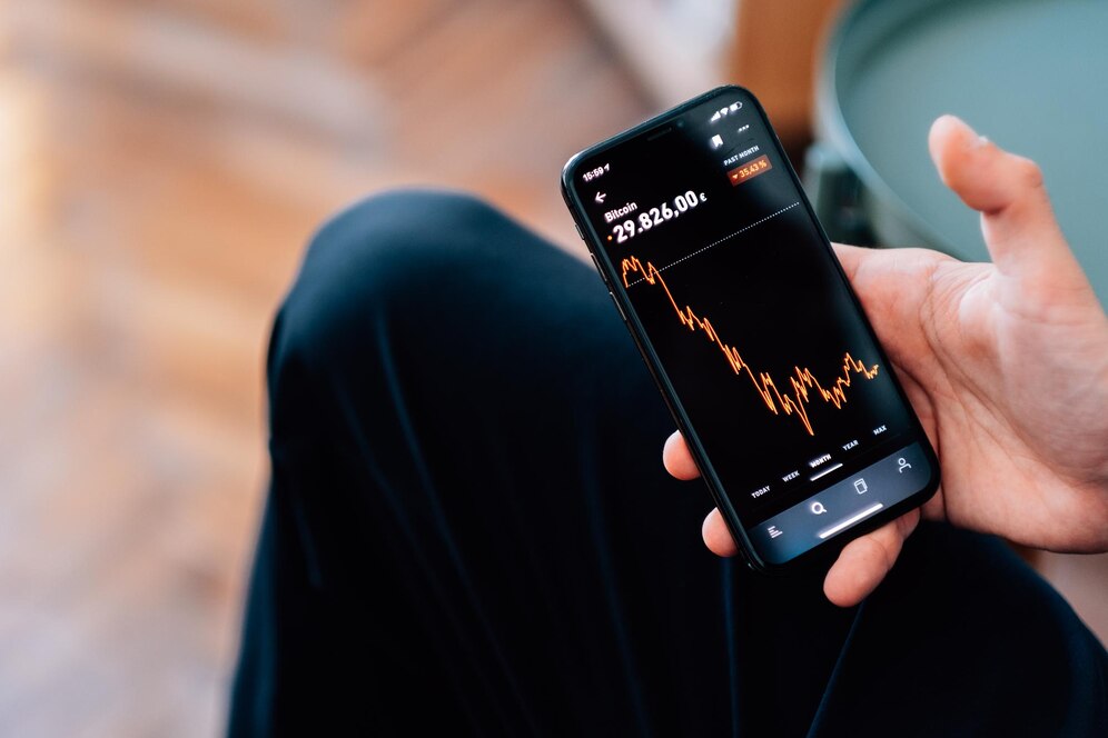 selective-focus-shot-male-hand-holding-smartphone-with-cryptocurrencies-statistics-screen_181624-59051